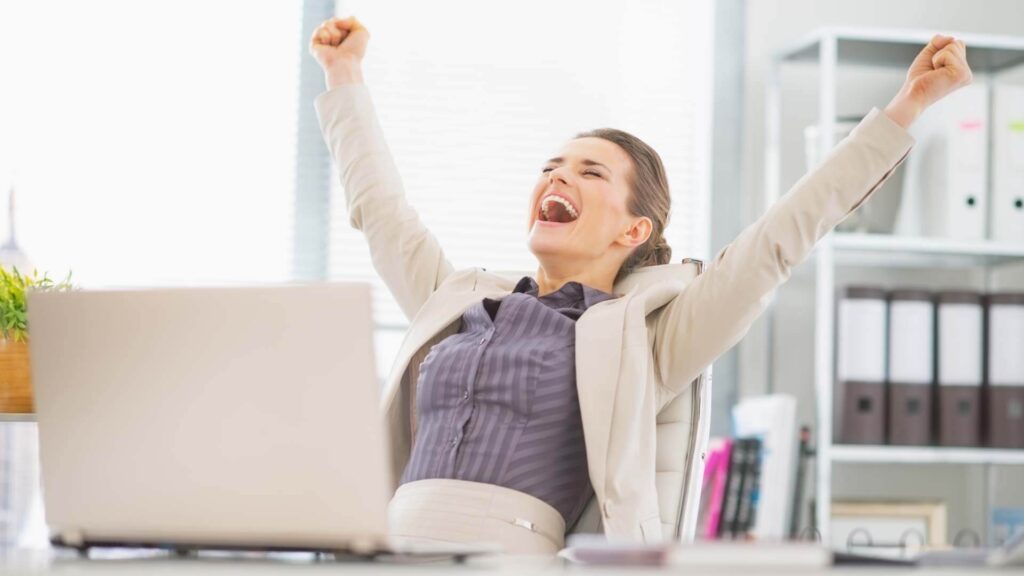 happy business woman in office rejoicing success of completing task